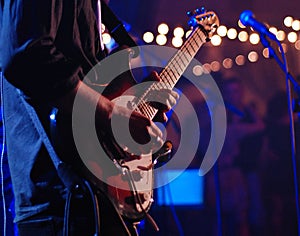 Guitarist live playing solo in focus. Blurred background