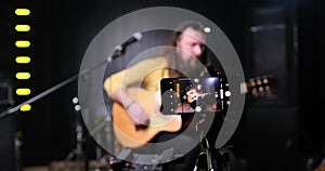 Guitarist man plays an acoustic guitar Close-up at studio