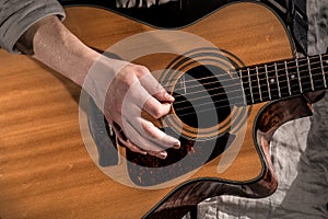 Guitarist, music. A young man plays an acoustic guitar on a black isolated background