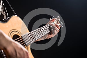 Guitarist, music. A young man plays an acoustic guitar on a black isolated background