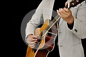 Guitarist playing acoustic guitar on black background