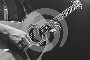 Guitarist playing acoustic guitar in the dark