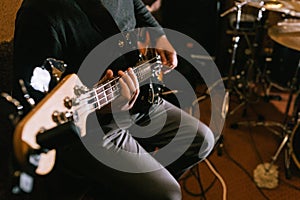 Guitarist playing bass guitar in studio closeup