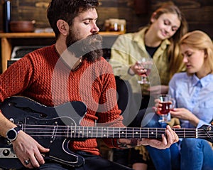 Guitarist playing at birthday, celebration concept. Bearded man performing guitar solo. Man with stylish beard