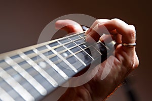 Guitarist playing a chord on a guitar fretboard close up