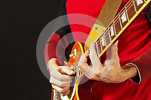 Guitarist playing the electric guitar on dark background