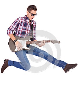 Guitarist playing an electric guitar while jumping