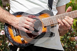 Guitarist playing an electric guitar outdoors.