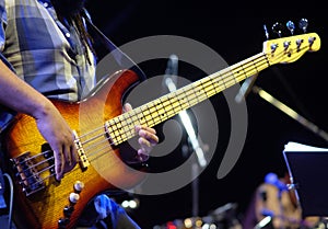 Guitarist playing electrical bass guitar on a jazz concert