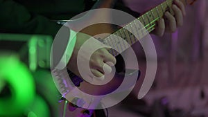 Guitarist playing guitar at concert. Musician with string instrument at stage.