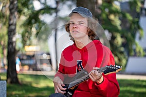 Guitarist playing guitar in summer park