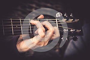 Guitarist Playing song on acoustic guitar fretboard chord vintage style