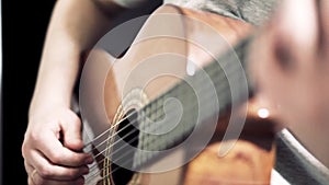 The guitarist plays an acoustic guitar. Guitarist hand and fretboard closeup