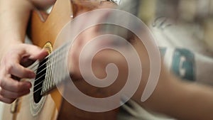 The guitarist plays an acoustic guitar. Guitarist hand and fretboard closeup