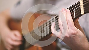 The guitarist plays an acoustic guitar. Guitarist hand and fretboard closeup