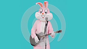 Guitarist plays acoustic guitar, sings song to retro vintage classic microphone, celebrates Happy easter