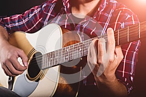 GUITARIST PLAYS ON THE ACOUSTIC GUITAR ON THE STAGE