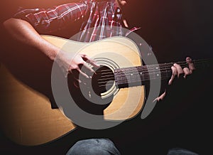 GUITARIST PLAYS ON THE ACOUSTIC GUITAR ON THE STAGE