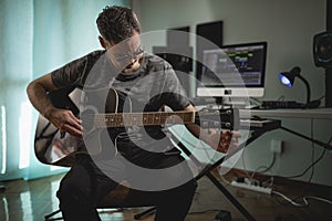 Guitarist and producer tuning his acoustic guitar