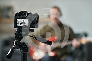 Guitarist recording his performance on camera