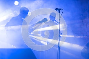 Guitarist silhouette perform on a concert stage. Abstract musical background. Music band with guitar player. Playing
