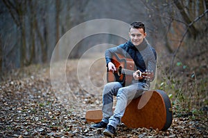 Guitarist singing outdoor in the forest