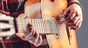 Guitarist on stage. Close up hand playing guitar. Guitars acoustic. Male musician playing guitar, music instrument