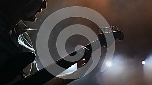 Guitarist on stage, musician tunes his instrument before the concert.