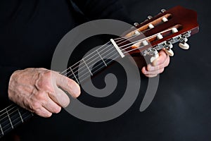 Guitarist tunes instrument, man plays the guitar, close-up hands, the concept of creativity, learning to play musical instruments