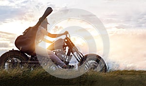 Guitarist woman riding a motorcycle on the countryside road