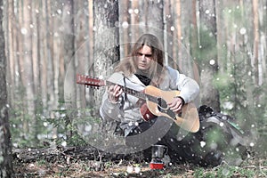 Guitarist in the woods at a picnic. A musician with an acoustic