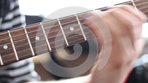 Guitarists hands playing song on electric guitar