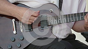 Guitarists hands playing song on electric guitar