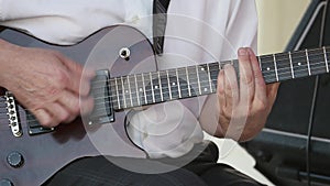 Guitarists hands playing song on electric guitar