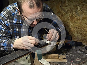 Guitars Luthiers checks the accuracy of the Nut setting.