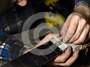 Guitars Luthiers checks the accuracy of the Nut setting.