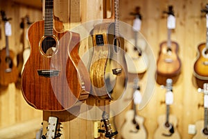 Guitars for sale hanging on a wall at a music store