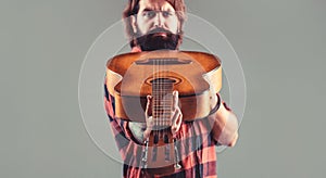 Guitars and strings. Bearded man playing guitar, holding an acoustic guitar in his hands. Music concept. Bearded