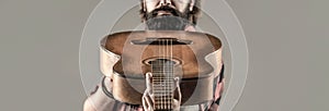 Guitars and strings. Bearded man playing guitar, holding an acoustic guitar in his hands. Music concept. Bearded