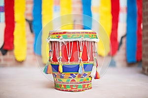 a gujarati dhol drum decorated with colorful tassels