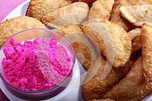 Gujias with pink color in bowl