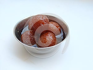 Gulab Jamoon or Jamun in a Steel, Green Color Plastic Cup and Spoon  on white Background