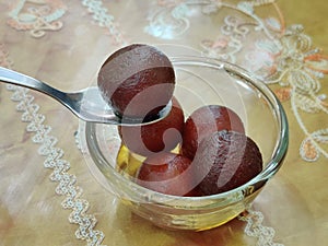 Gulab jamun serving in glass bowl, a milk-solid-based sweet from the Indian subcontinent, and a type of mithai. traditional Indian