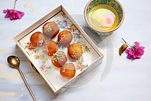 gulab jamuns packed in a festive sweet box