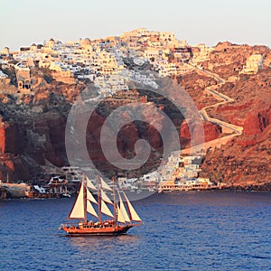 Gulet Sailing In Front Of Oia And Athinios Harbor