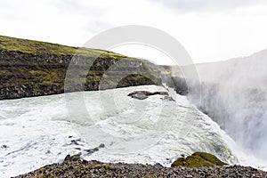 Gullfoss waterfall and water spray over canyon
