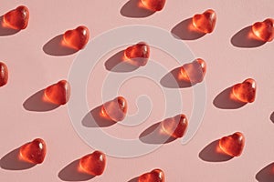 Gummy heart shaped candy layout against pink coral background.