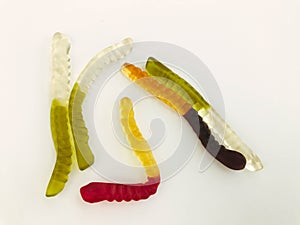 Gummy worms lie on a white matte background. bright, mouth-watering gelatinous worms of different colors. delicious and sweet