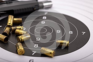Gun and bullets on bull eye target for shooting practice
