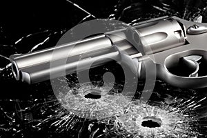 Gun with bullet holes in glass